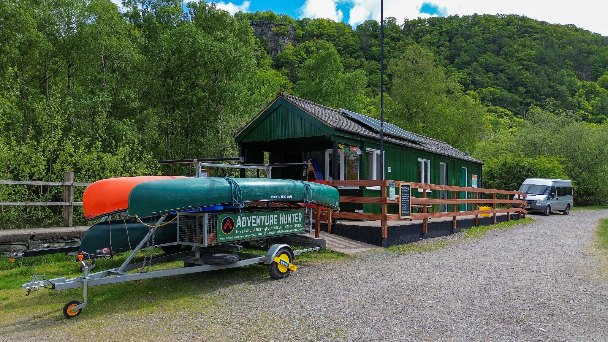The Adventure Hunter Boathouse with canoes outside, surrounded by woodland