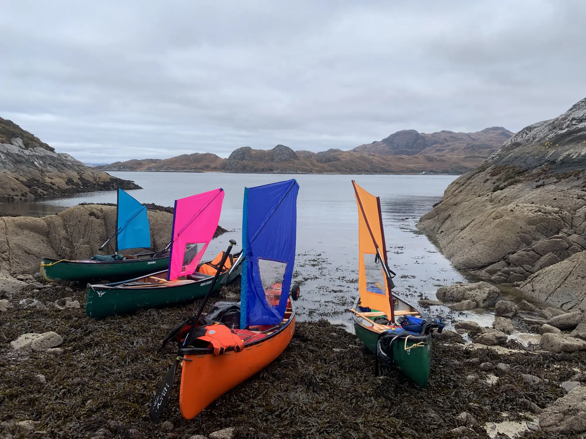 Loaded open canoes on a rocky shoreline