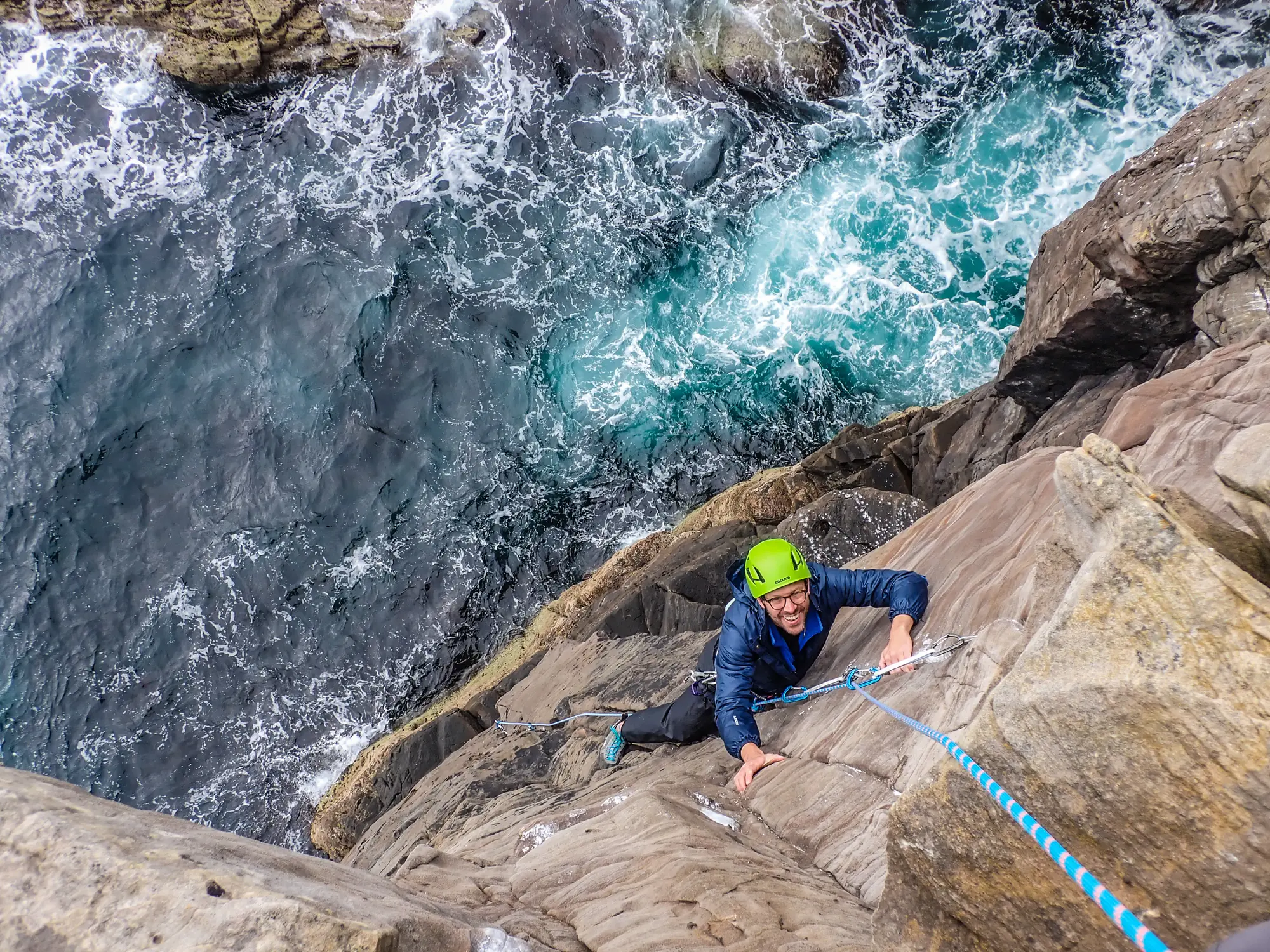Climber on coastal rock above the sea