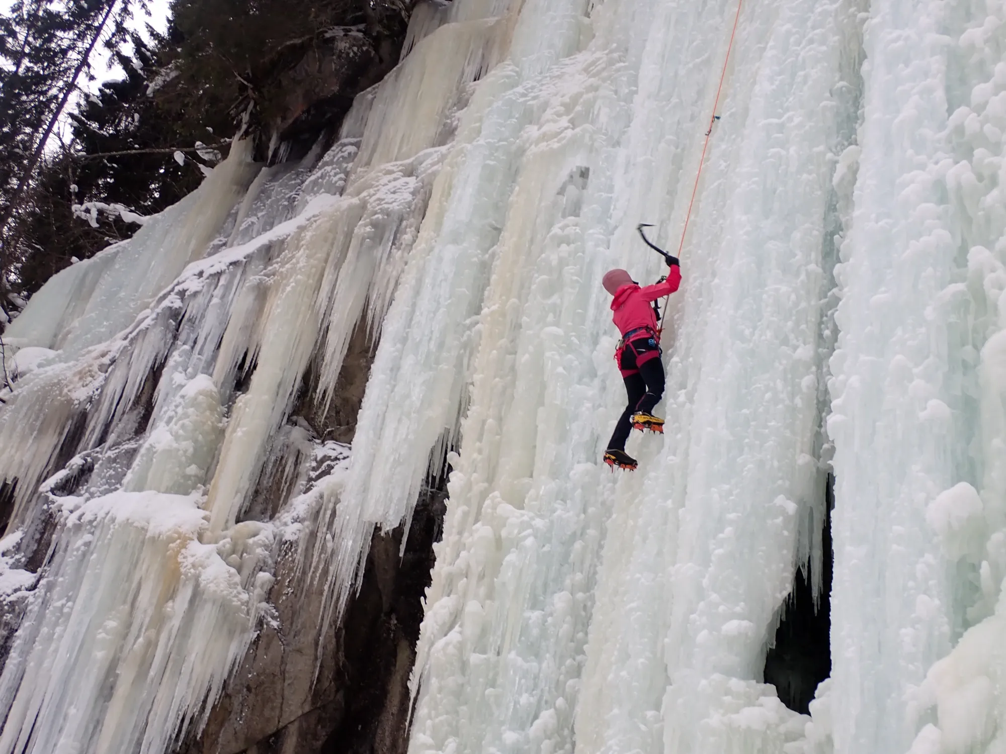 Ice climber ascending a frozen waterfall in Norway