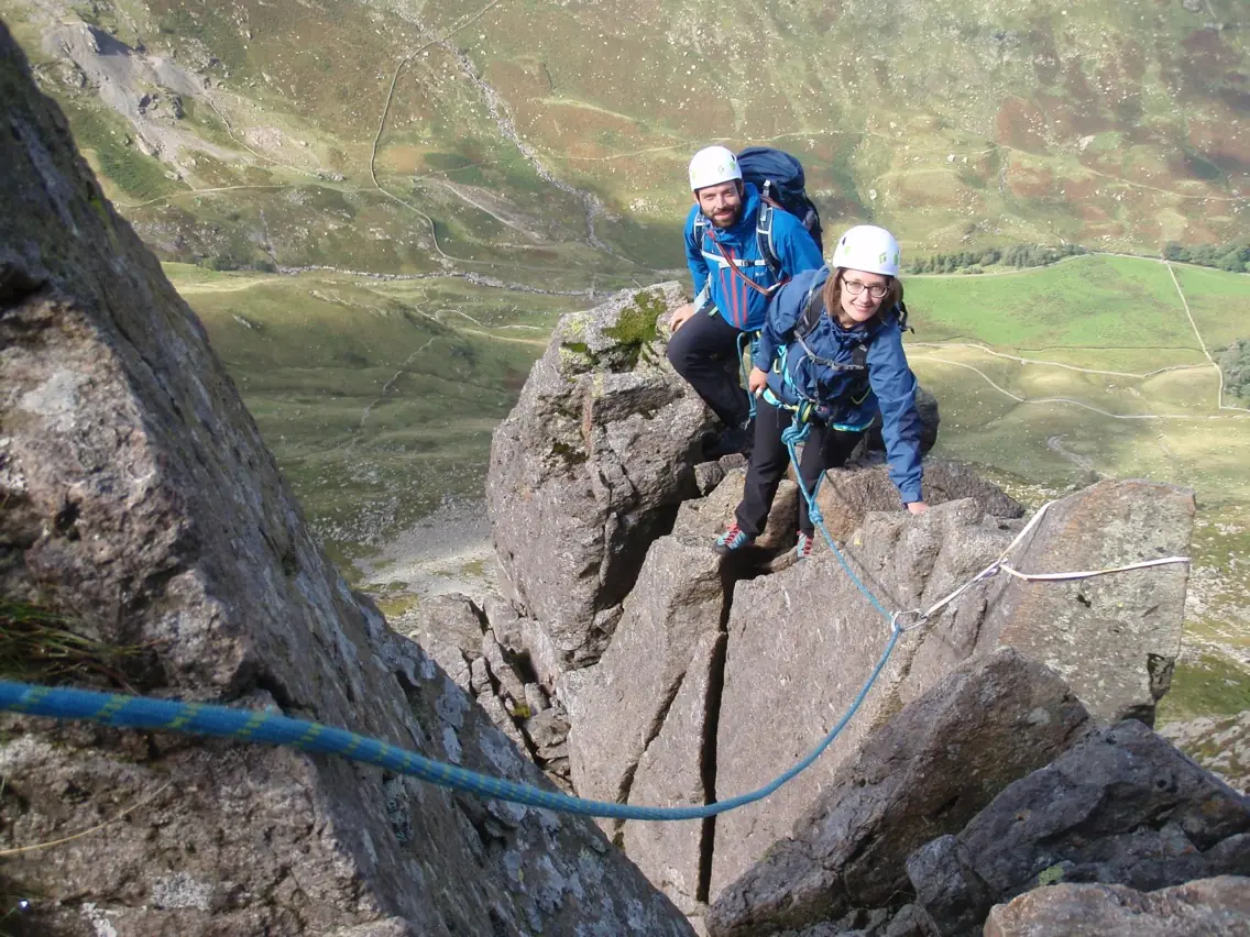 Two climbers scrambling on a rocky ridge